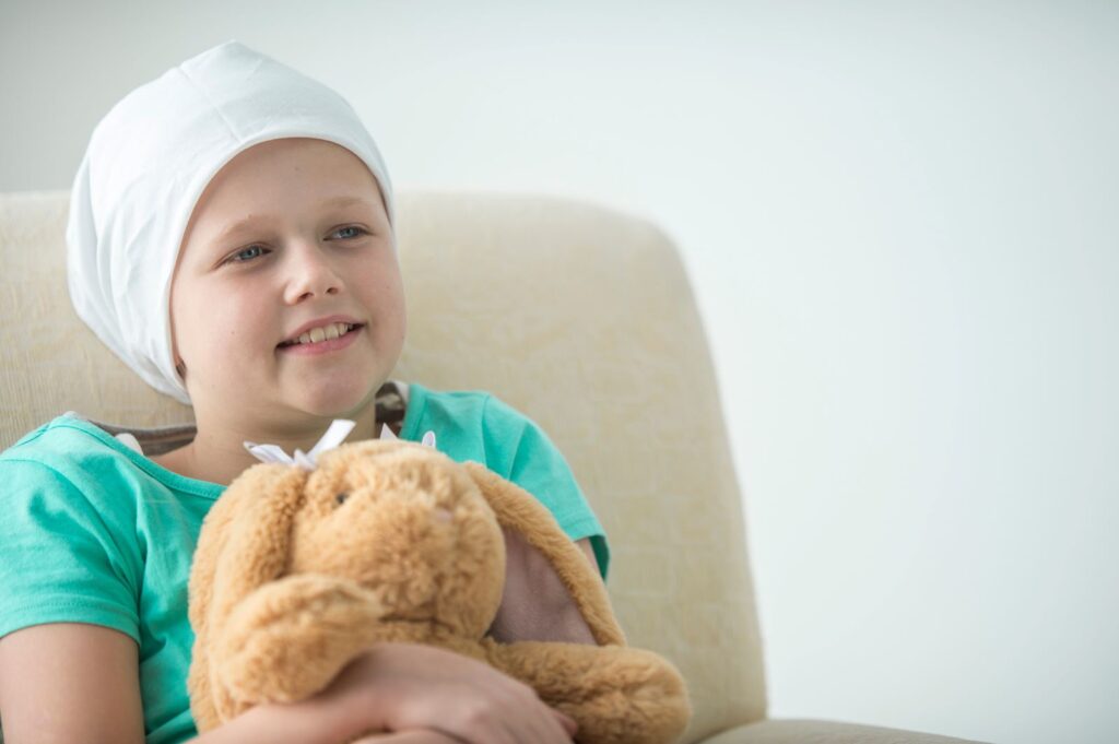 jente sitter i stol med bamse