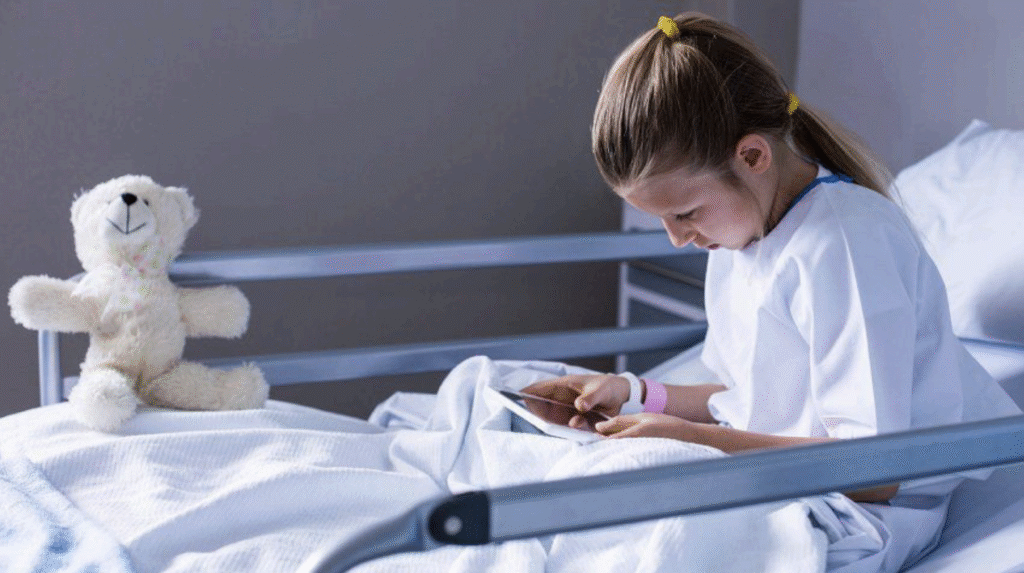Jente i sykeseng med bamse
